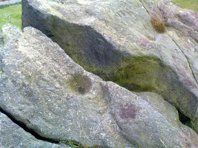 One of several sharp well-defined 'cups' on the rock