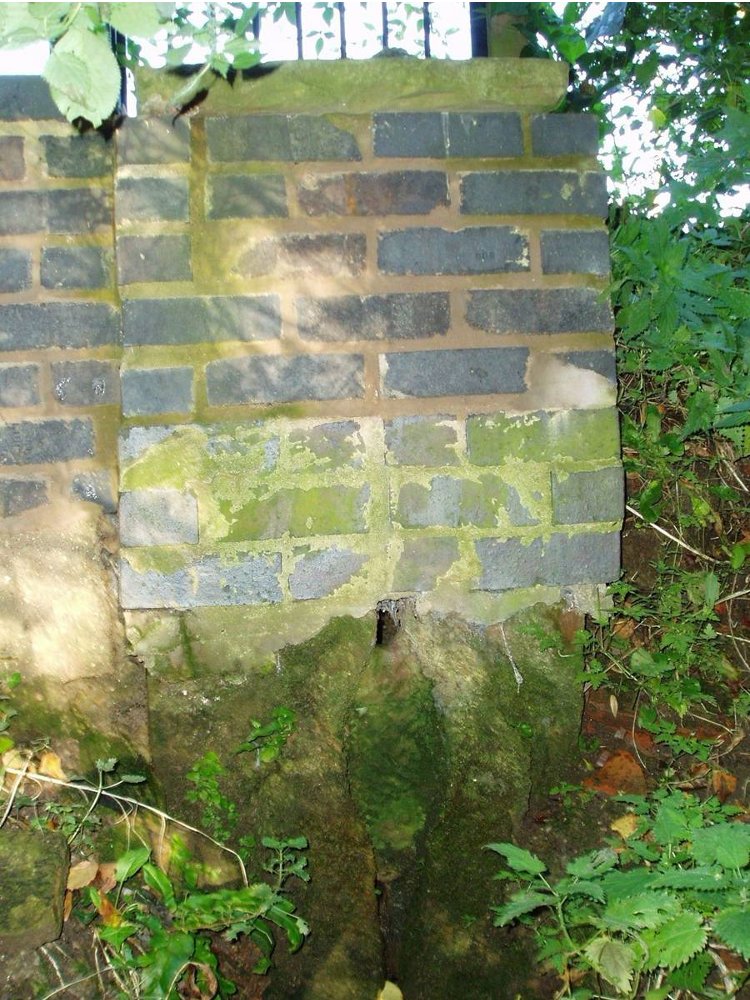 Modern stone wall above well